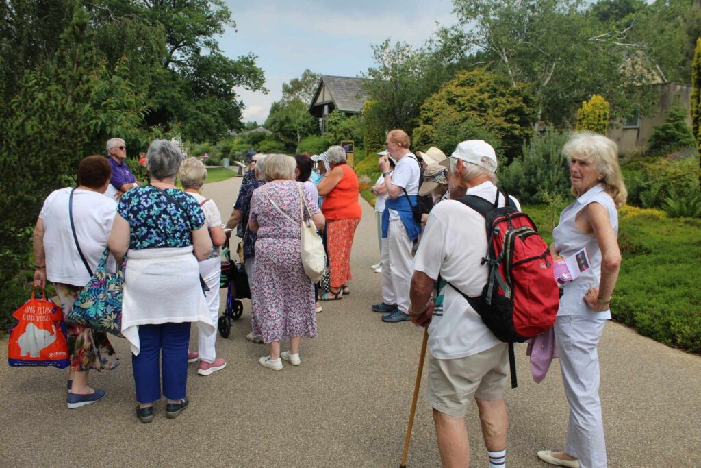 a GROUP OF MEMBERS LISTENING INTENTLY TO A GUIDE AT hARLOW cARR