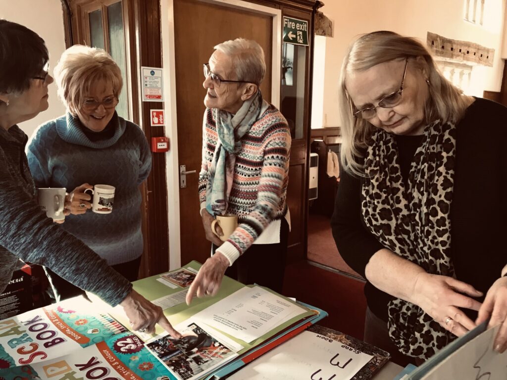 four ladies looking at an Archive collection and discussing the items
